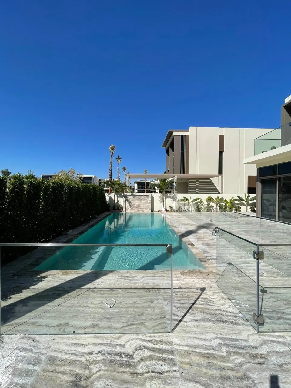 Plage de piscine en travertin et garde-corps en verre, réalisation Dekorenov