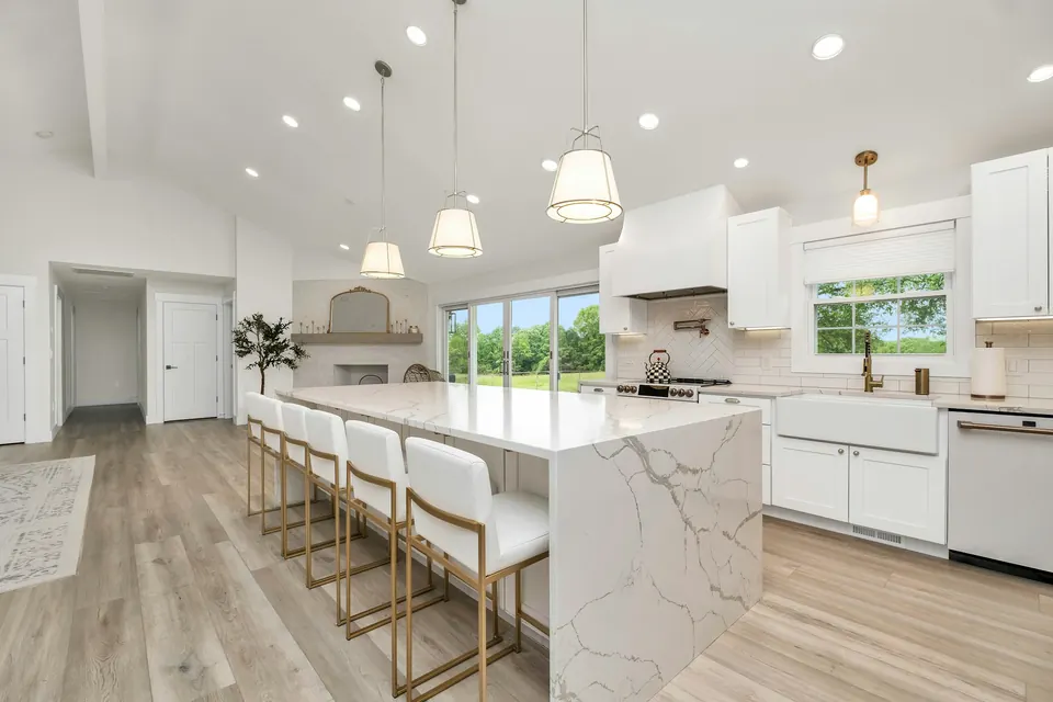 Marble island with white kitchen cabinets