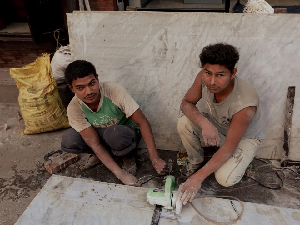 Deux artisans découpant des tranches de marbre